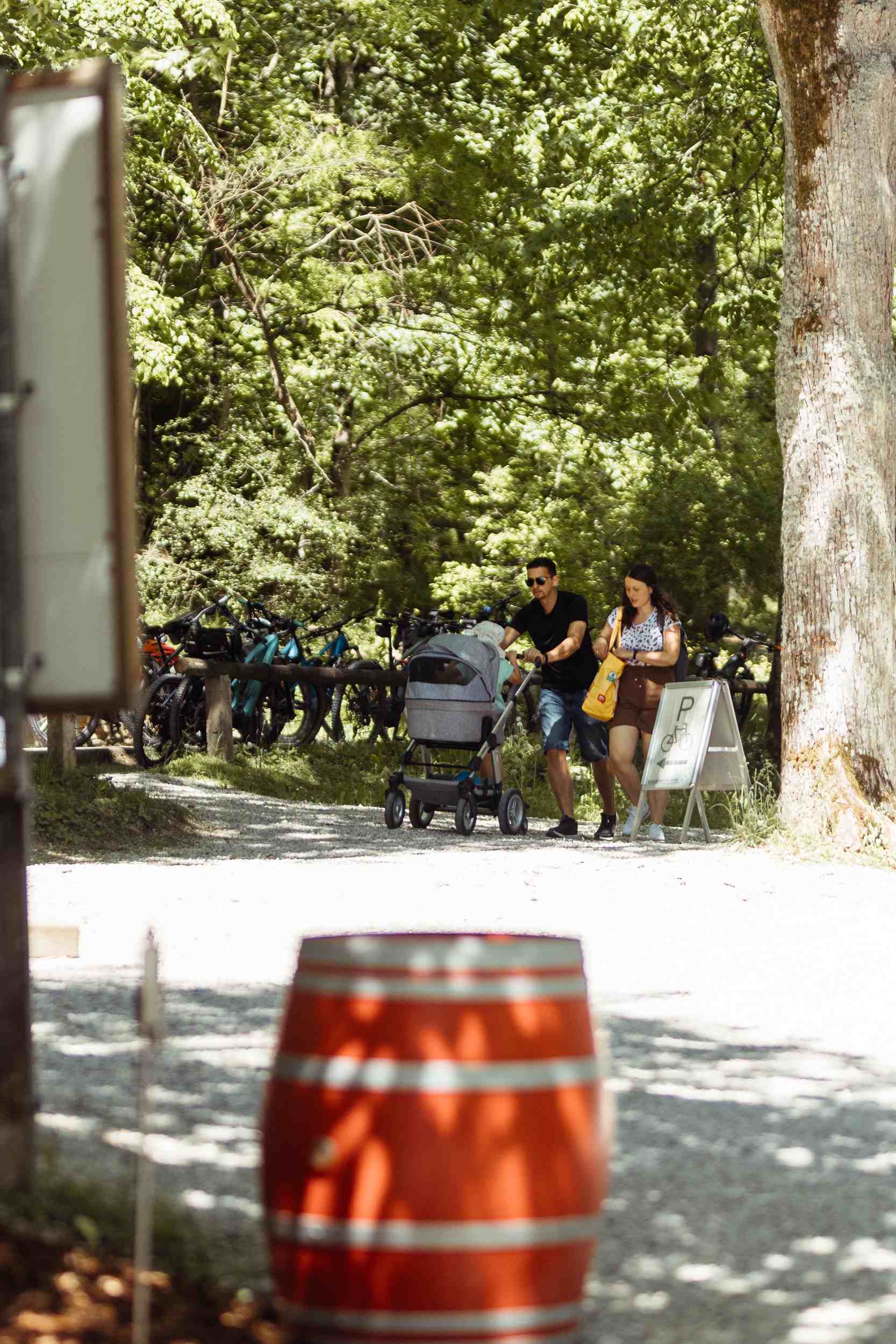 Familie mit Kinderwagen und Fahrrädern auf dem Weg zum Biergarten
