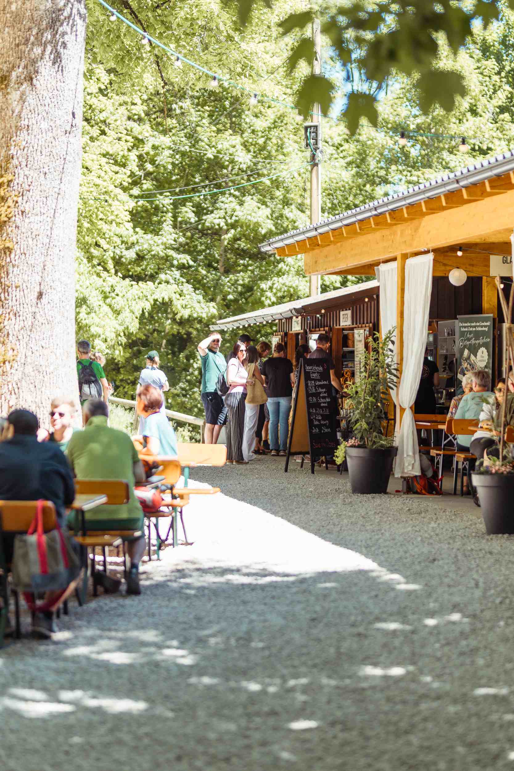 Langer Sitzbereich mit Biergartentafeln entlang eines Wegs